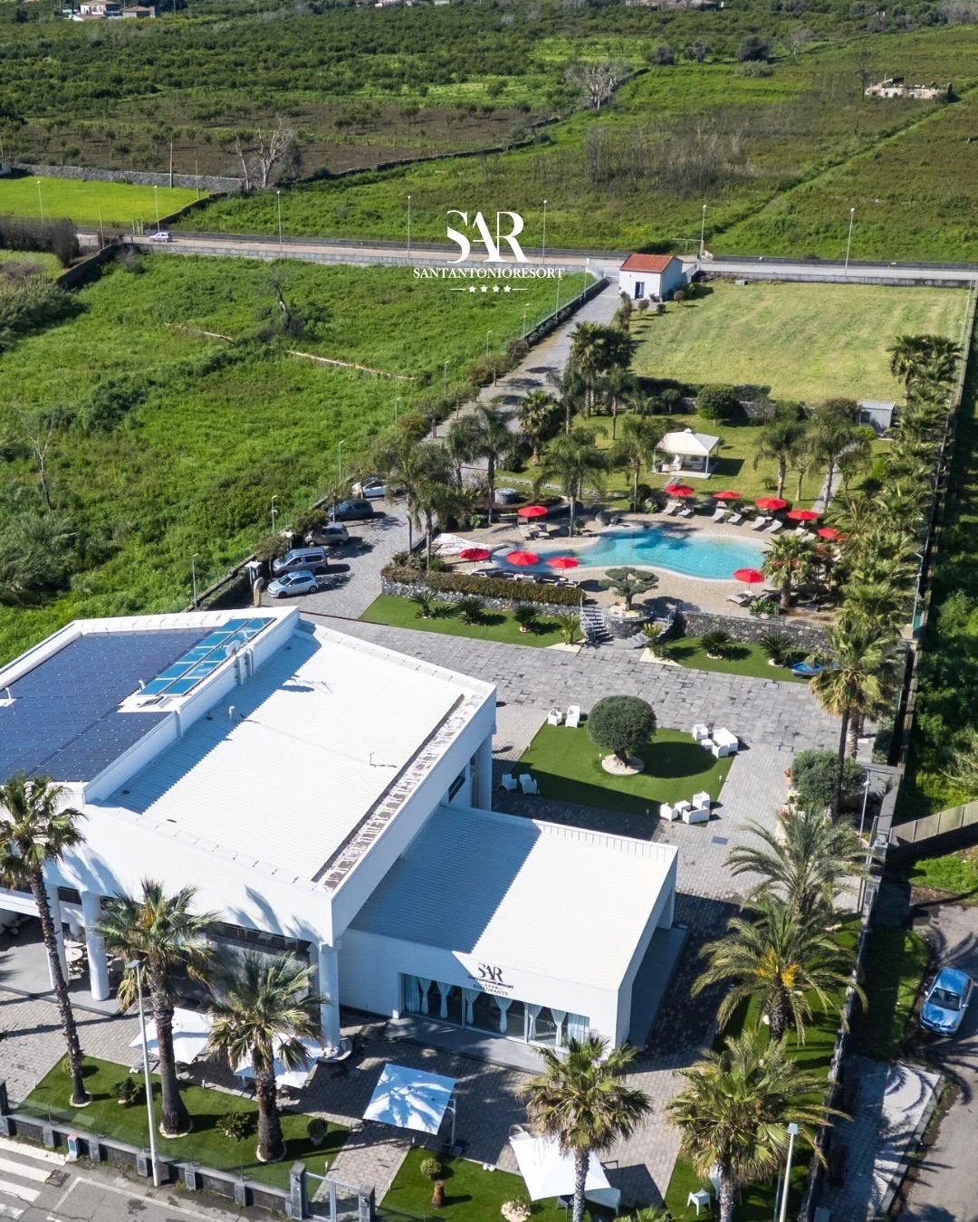 Vista aerea del resort con giardino e lago-piscina