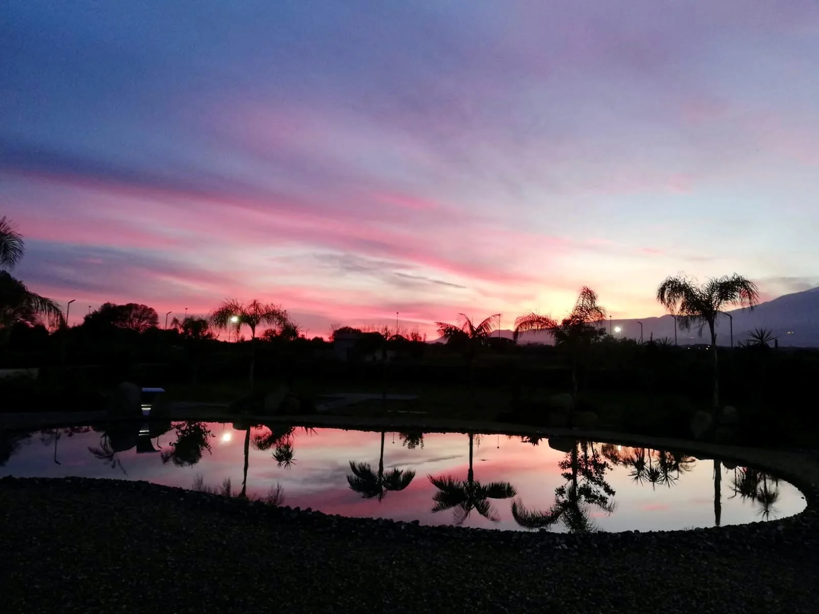 Piscina del Santantonio Resort con cielo rosa al tramonto